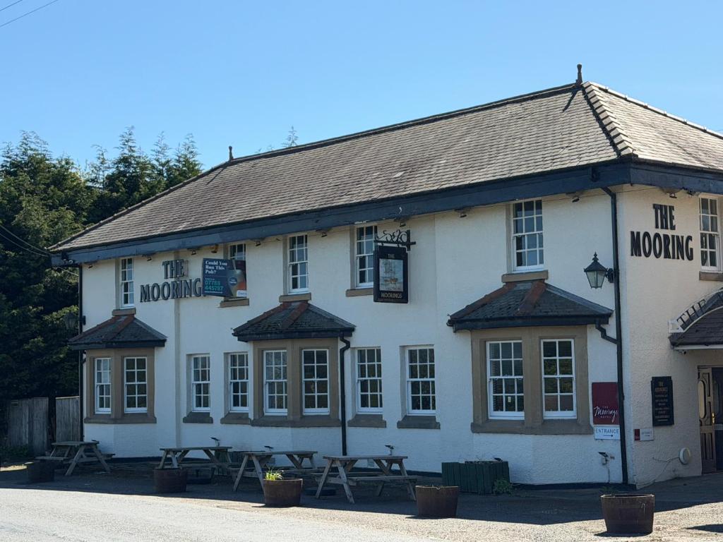 a white building with picnic tables in front of it at The Moorings in Edmondsley