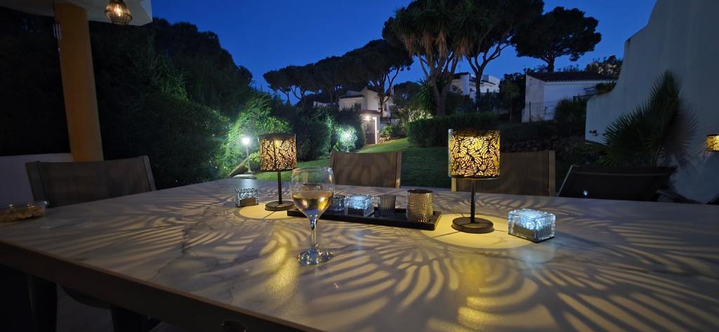 a table with two glasses of wine and lights on it at 7 Ocean Point in Sitio de Calahonda