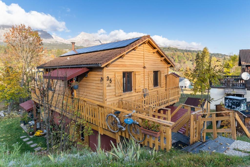 a log cabin with a porch and a bike parked in front at Chalet le 22 Agniéres in Le Dévoluy