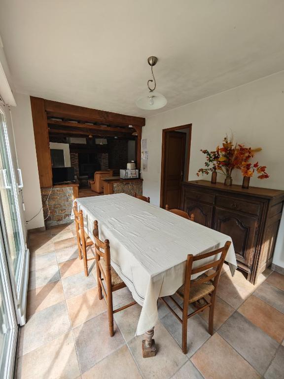 a dining room with a table and chairs and a fireplace at La Belangerie in Saint-Loup