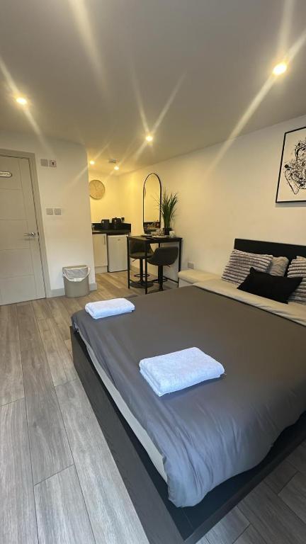 a bedroom with a bed with two towels on it at Brigstock 9 in Thornton Heath