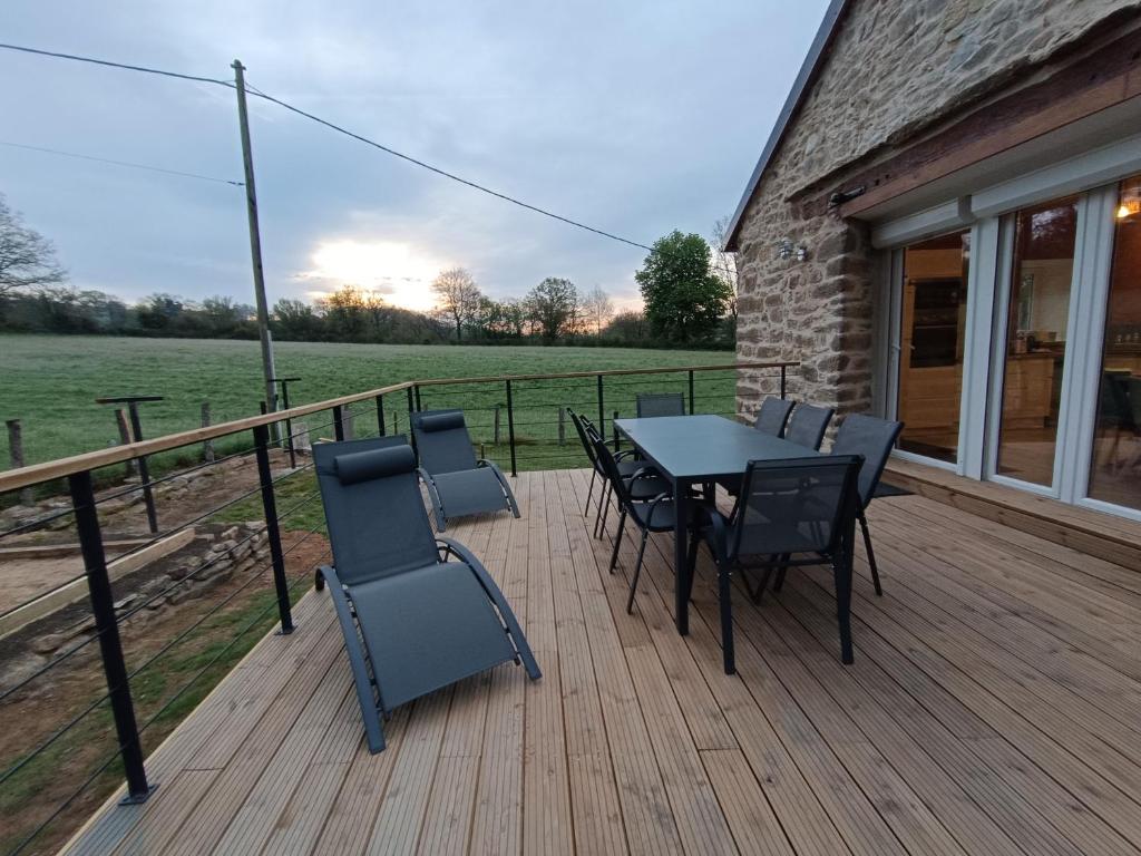 a patio with a table and chairs on a deck at La Grange de Céor in Cassagnes-Bégonhès