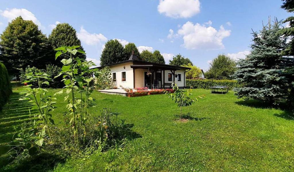 a small white house in a field of grass at Bungalov pod Lípami in Mladějov