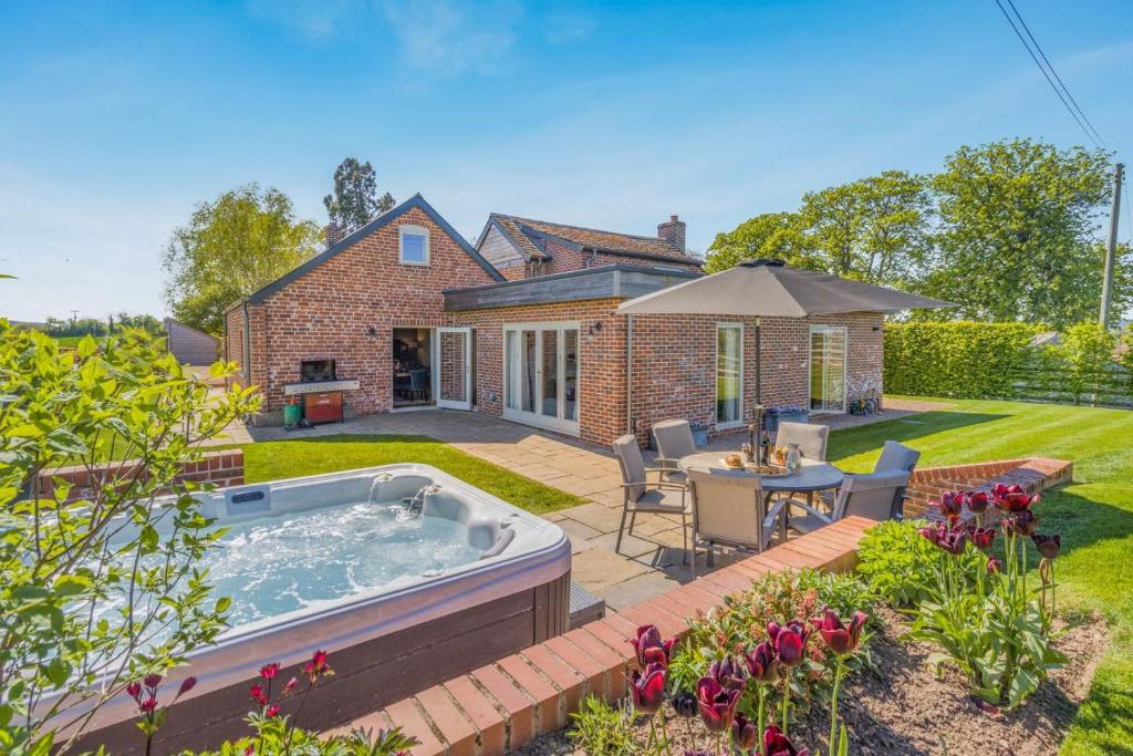 a backyard with a hot tub and a table and chairs at 3 Bed in Hereford oc-83659 in Madley