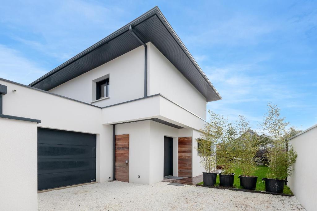 a white house with a black roof at violette in Pornichet