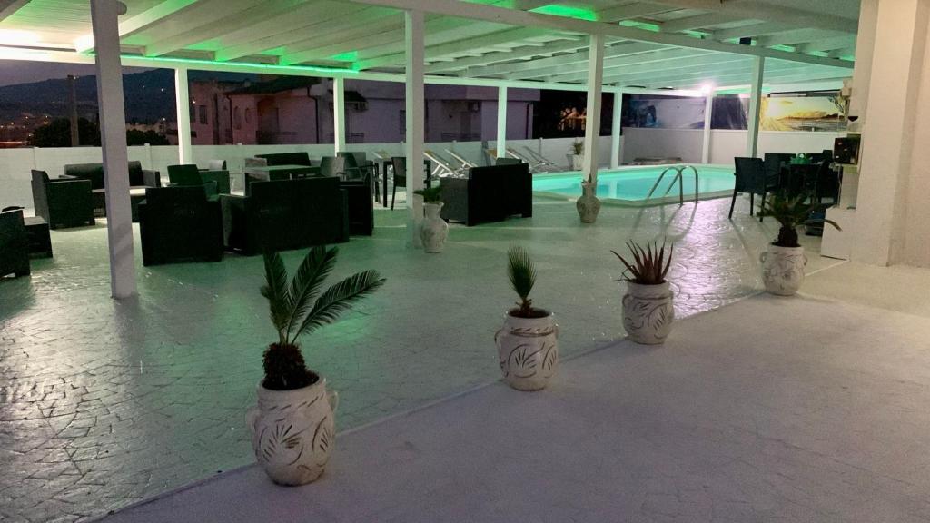 a lobby with three white pots with plants in them at la perla dello ionio in Satriano