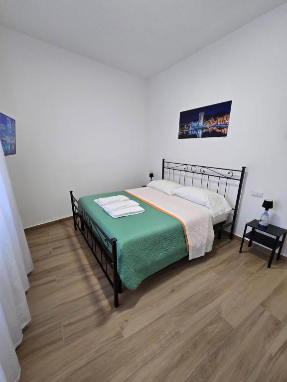 a bedroom with a bed and a wooden floor at DOMUS AISA appartamenti Formia centro in Formia