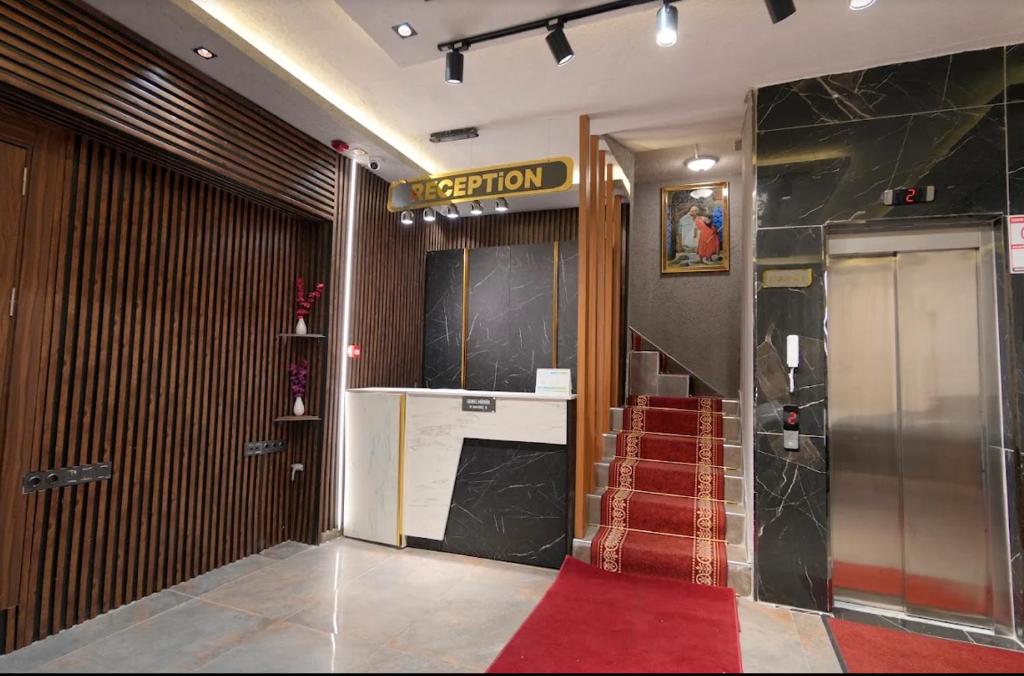 a lobby with a red carpet and a elevator at Divan Tower Otel in Erzurum