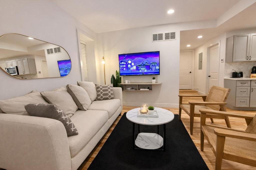 a living room with a white couch and a table at Charming 1-Bed Apt WiFi, Fully Equipped Kitchen in Rochester