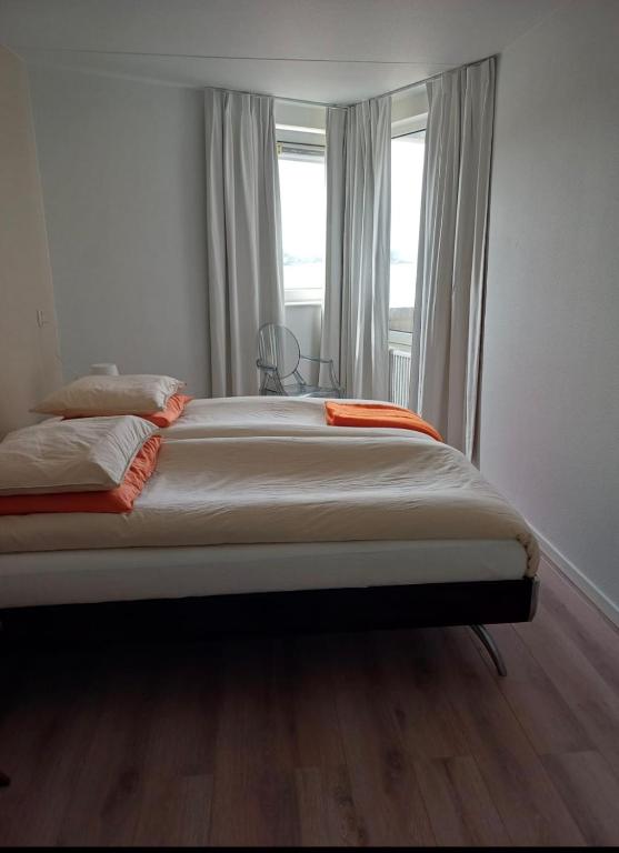 a large bed in a room with a window at Strandappartement Iselmar Makkum nr 30 in Makkum