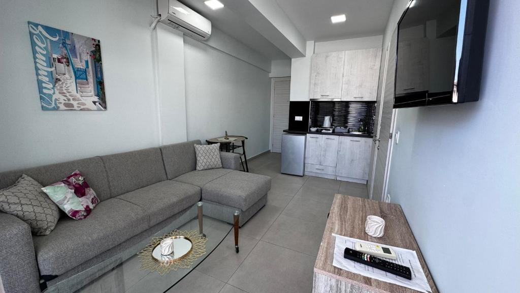 a living room with a couch and a table at Bella Luxury Suite III in Paralia Katerinis