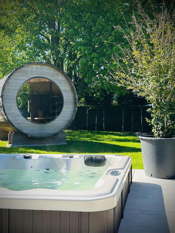 a jacuzzi tub sitting in a yard with a circle at Het Huis - luxury villa near Tomorrowland in Willebroek