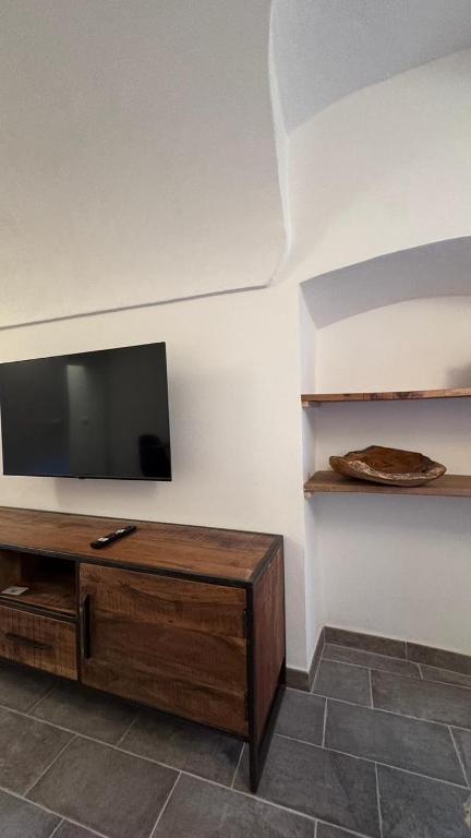 a living room with a flat screen tv on a wall at Residence by Talking Stones in Dolceacqua