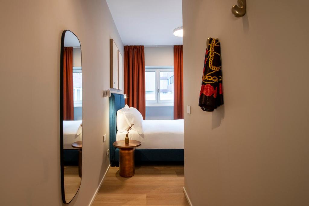a hallway with a bedroom with a bed and a mirror at RELSTAY - Vercelli Suites in Milan