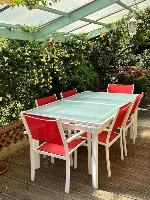 a white table with four red chairs on a deck at Clos Sainte Marguerite in Lambesc