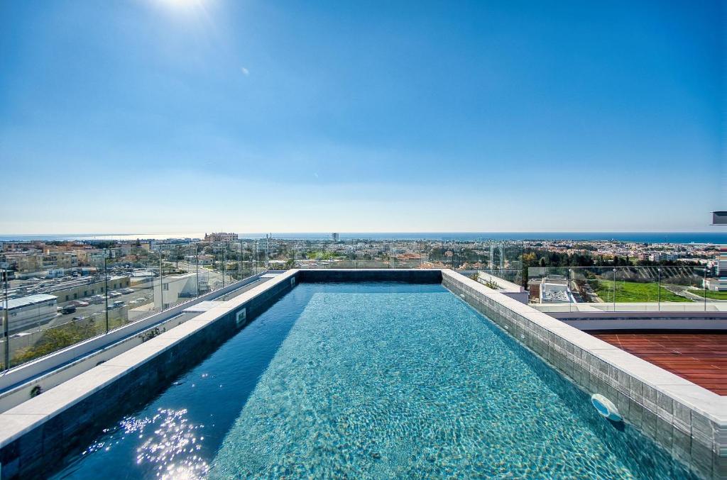 a swimming pool on the roof of a building at Modern Sea-View Work Apartment, Sit-Stand Desk, Pool, Gym & Walk to Old Town in Paphos