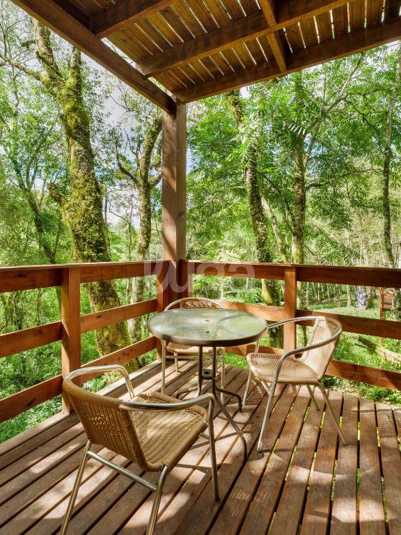 a patio with a table and chairs on a deck at Suite Low – Cyclists' Paradise in Gramado