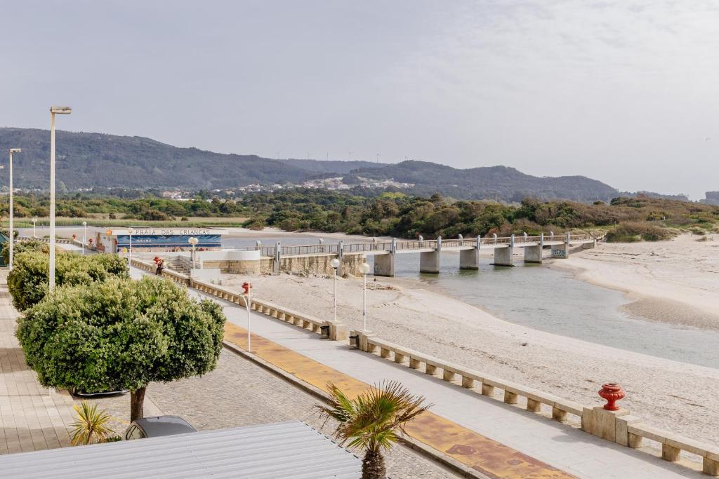 a bridge over a river next to a beach at BESTVILLAS Âncora Rio in Vila Praia de Âncora