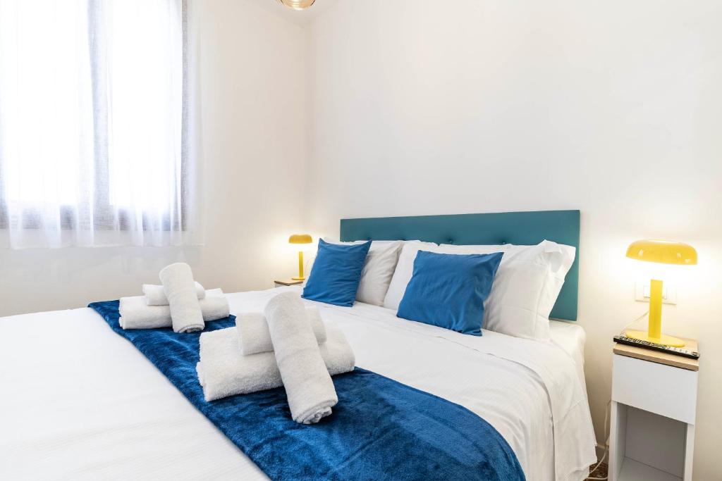 a bedroom with a large white bed with blue accents at Rigoletto Apartments by Fenix in Venice