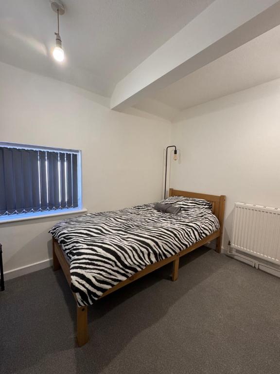 a bedroom with a zebra print bed in a room at Serenity LTD in Leicester
