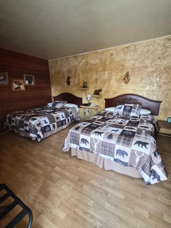 a bedroom with two beds and a wooden floor at Chateau Lodge in Oregon