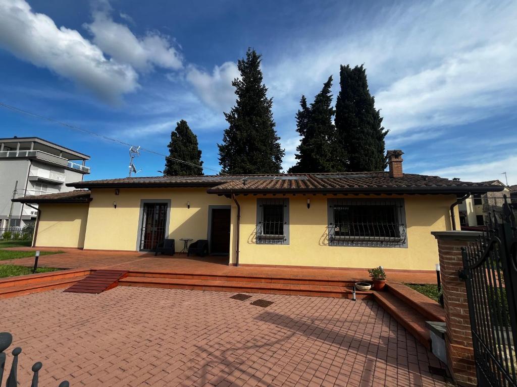 a small yellow house with a brick patio at Antico Granaio di LEO Via Antonia 60 in Ponte Pattoli