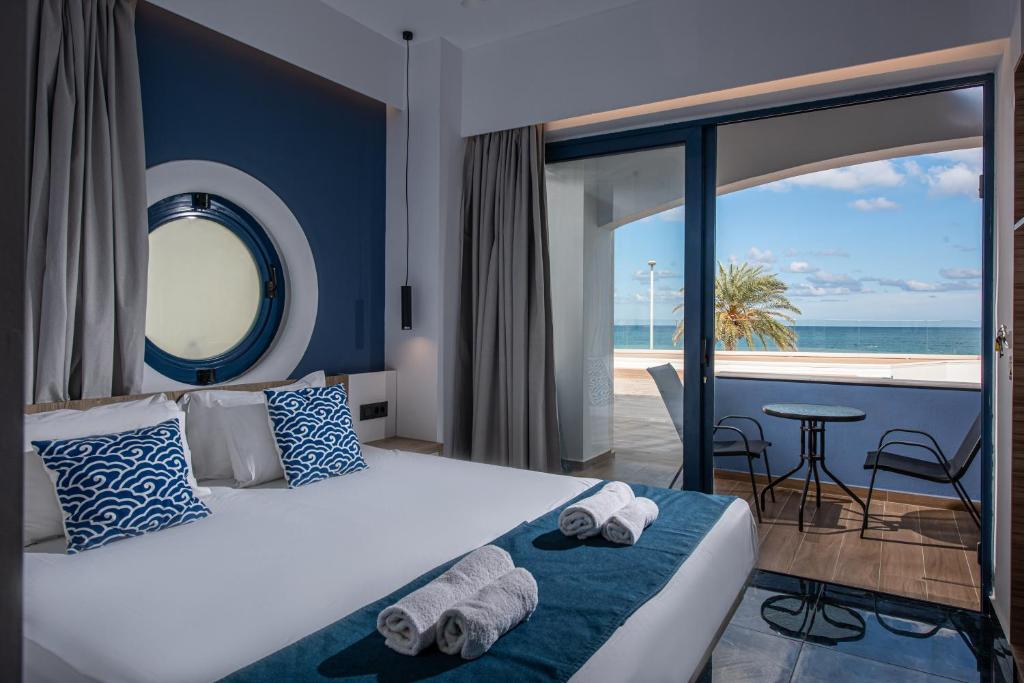 a bedroom with a bed with a view of the ocean at Eleni Beach Apartment in Stalís