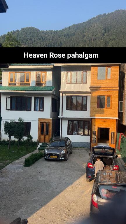 two cars parked in a parking lot in front of a house at New Heaven Rose in Pahalgām