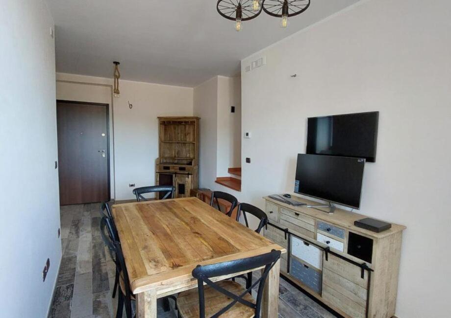 a room with a wooden table with chairs and a television at Borgo Tibetano in Castelsaraceno