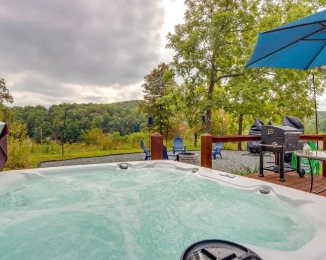 a hot tub with a table and an umbrella at Sunrise Cottage in Blue Ridge