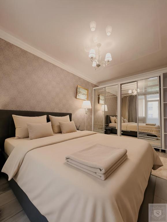 a bedroom with a large white bed with a mirror at RentHouse Apartments Premium Living in Chişinău
