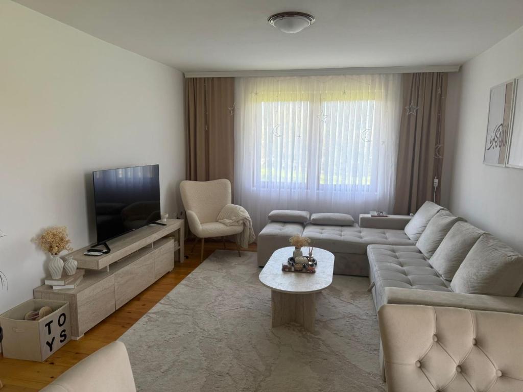 a living room with a couch and a tv at Butmir house-Sarajevo in Sarajevo