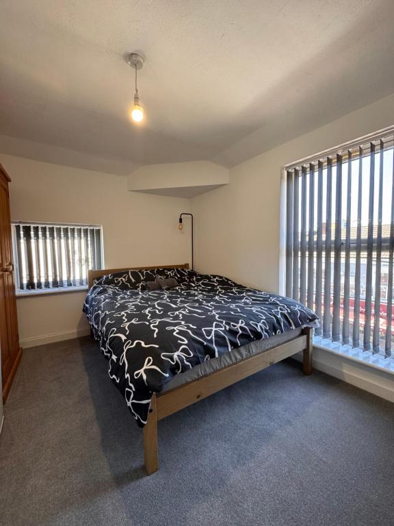 a bedroom with a bed in a room with windows at Serenity LTD in Leicester