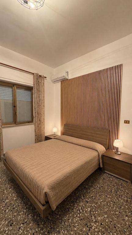a bedroom with a large bed with two tables and two lamps at Una rosa sul mare Monopoli in Monopoli