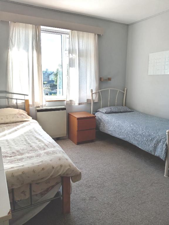 a bedroom with two beds and a window at Sawston Village in Sawston