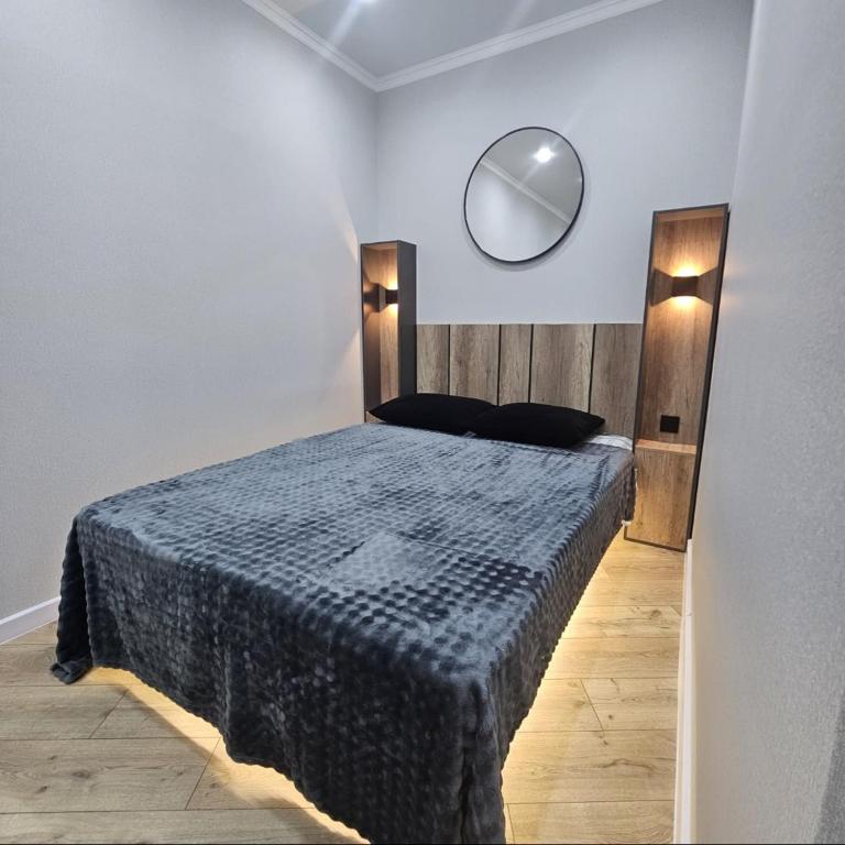 a bedroom with a bed with a mirror on the wall at Бауржан Момушелы 28 in Fëdorovka