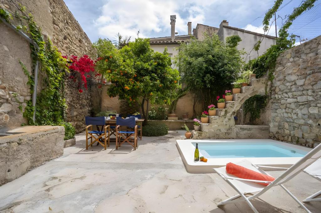a backyard with a pool and a table and chairs at Ca Sa Padrina in Artá