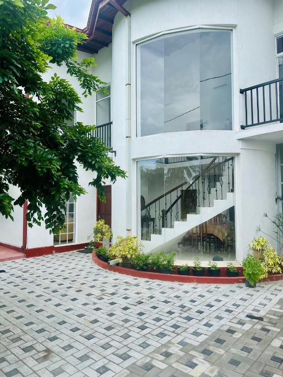 a white building with windows and a courtyard at Hamilton Breeze villa in Pamunugama