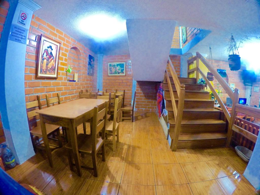 a dining room with a table and a staircase at Hostal Nomada in Baños