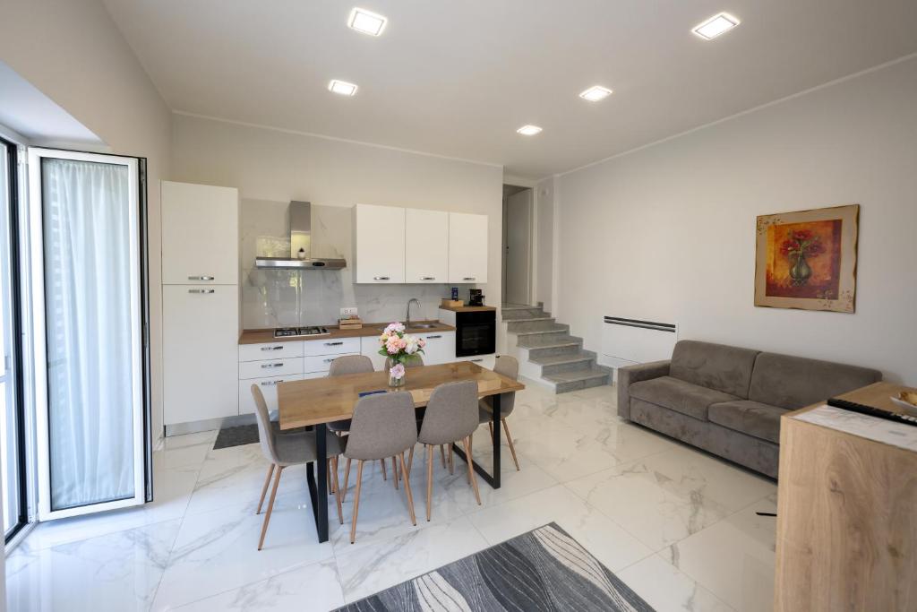 a kitchen and living room with a table and a couch at Dimora Ambrosio 108 in San Giuseppe Vesuviano