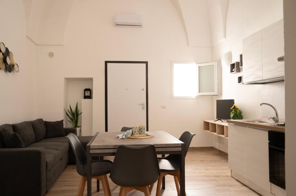 a kitchen and a living room with a table and chairs at Sarmalia 32 a pochi passi dal centro di Nardò in Nardò