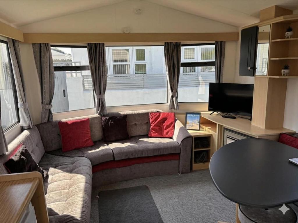a living room with a couch and a tv at Cornish Dreams - WiFi in Newquay