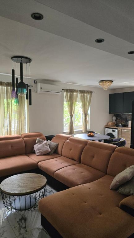 a living room with a brown couch and a table at Apartman NIKOL in Senj