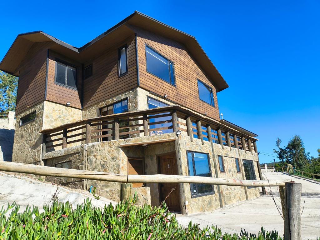 a large wooden house on top of a hill at Casa Hotel Los Arrayanes in Constitución