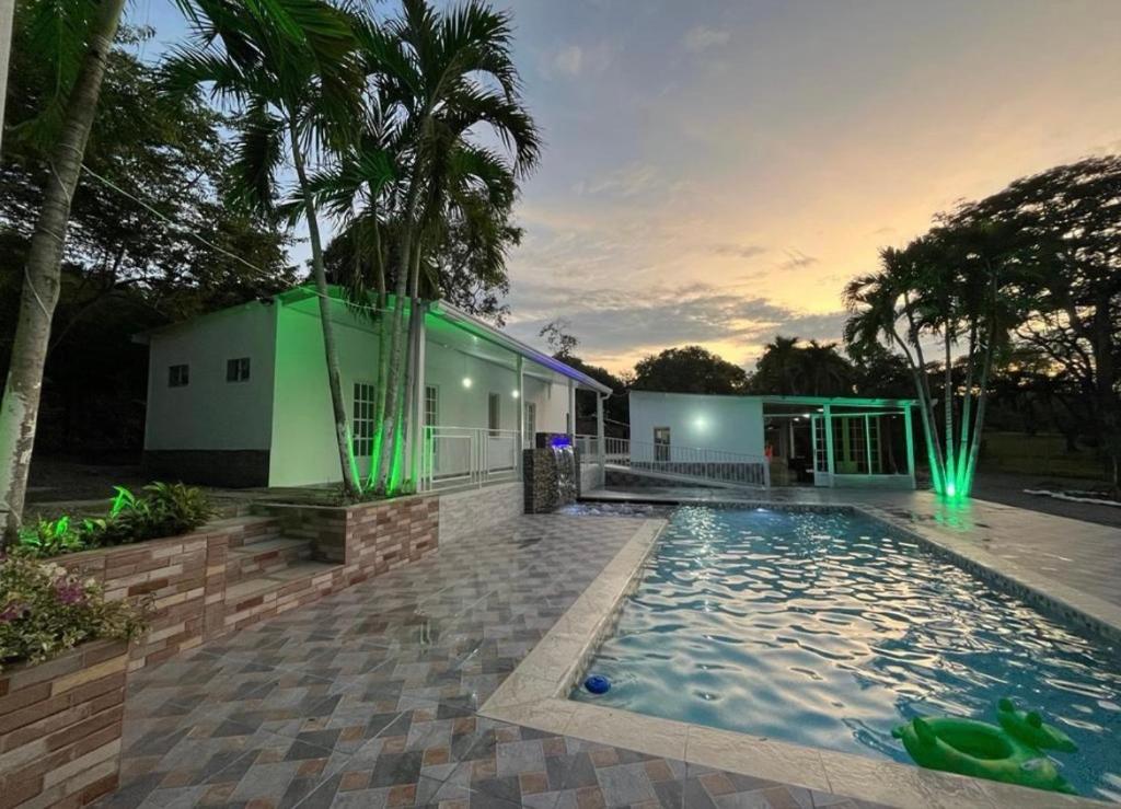 a house with a swimming pool in front of a building at Finca Nirvana. in Agua de Dios