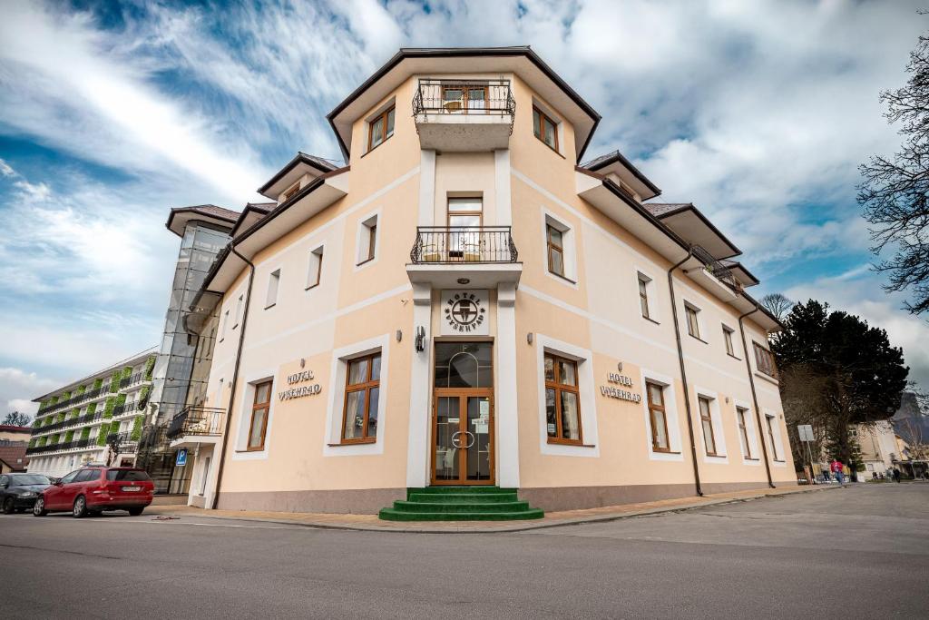 a large building with a clock on it on a street at Hotel Vyšehrad in Turčianske Teplice