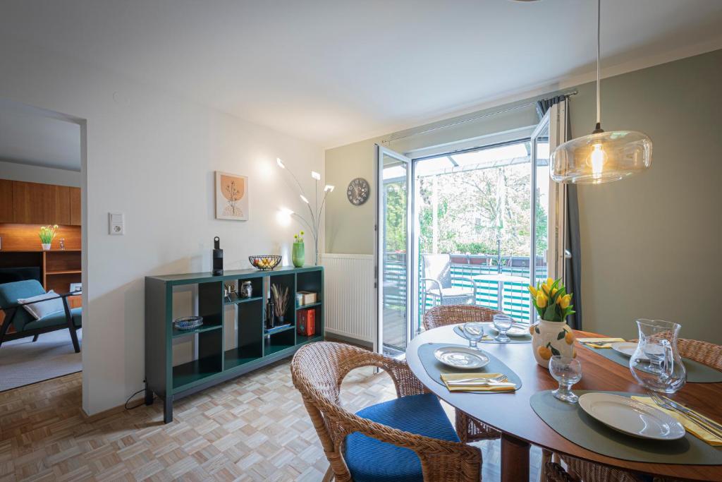 a dining room with a table and chairs and a living room at Modernes Ferienhaus Dornbirn mit 2 Schlafzimmern 2 Bädern nahe Bodensee & Bregenzerwald in Dornbirn
