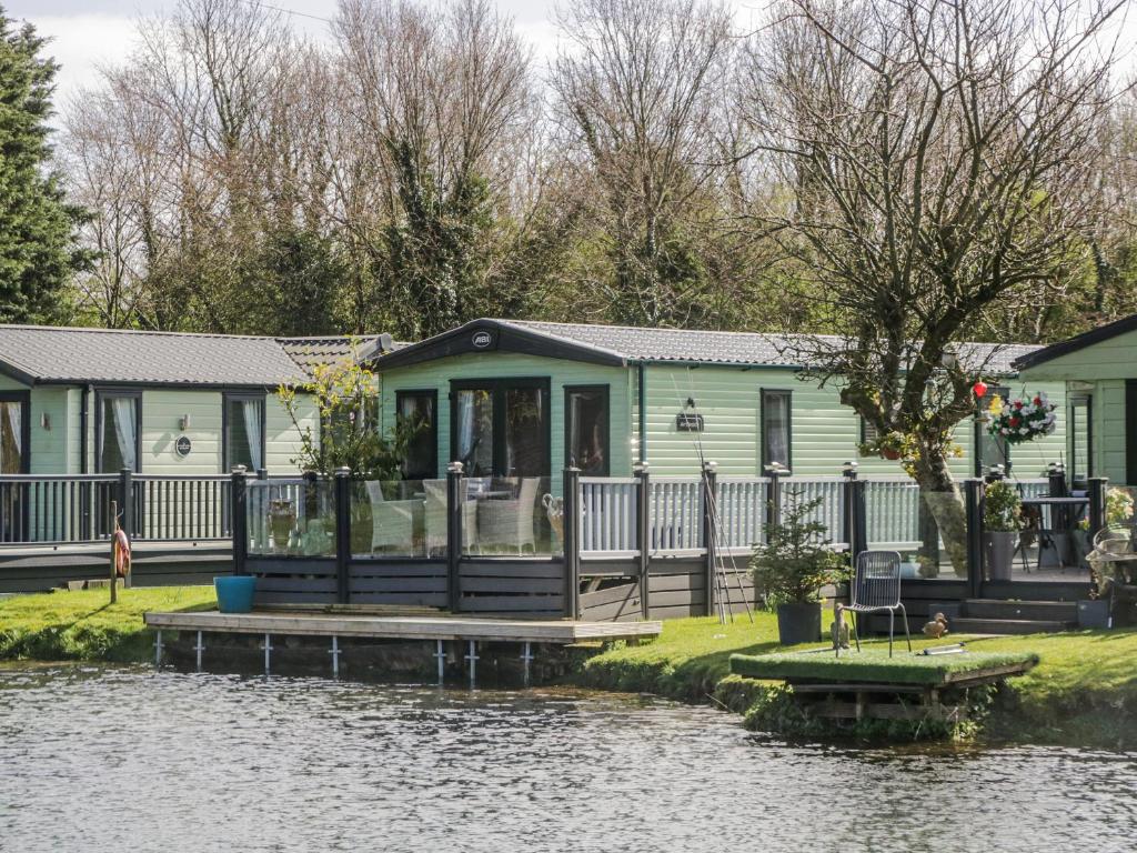 a house on the side of a river at Carp Lodge in Carnforth