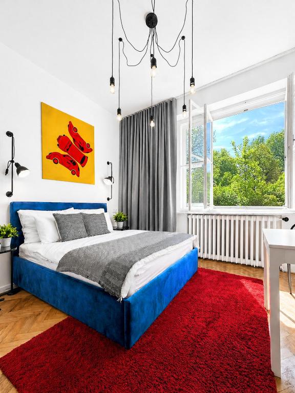 a bedroom with a blue bed and a red rug at Botanique Rooms with Sauna by Homester in Brno