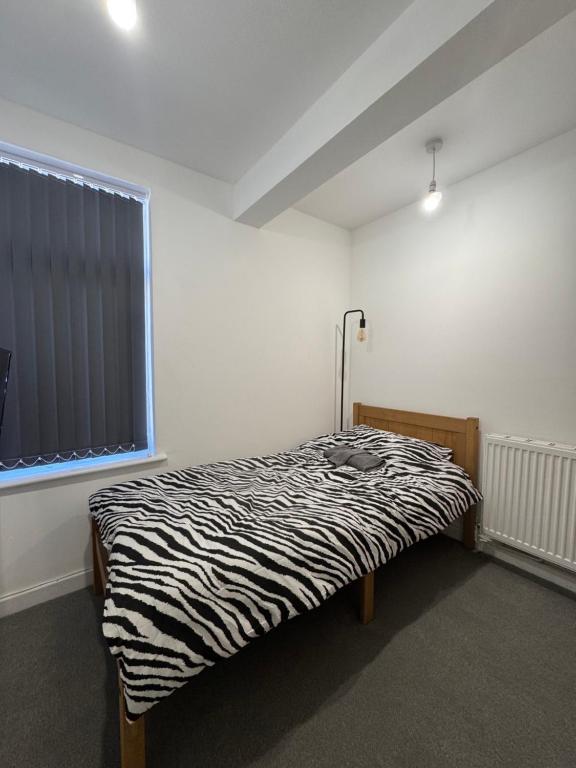 a zebra print bed in a room with a window at Serenity LTD in Leicester